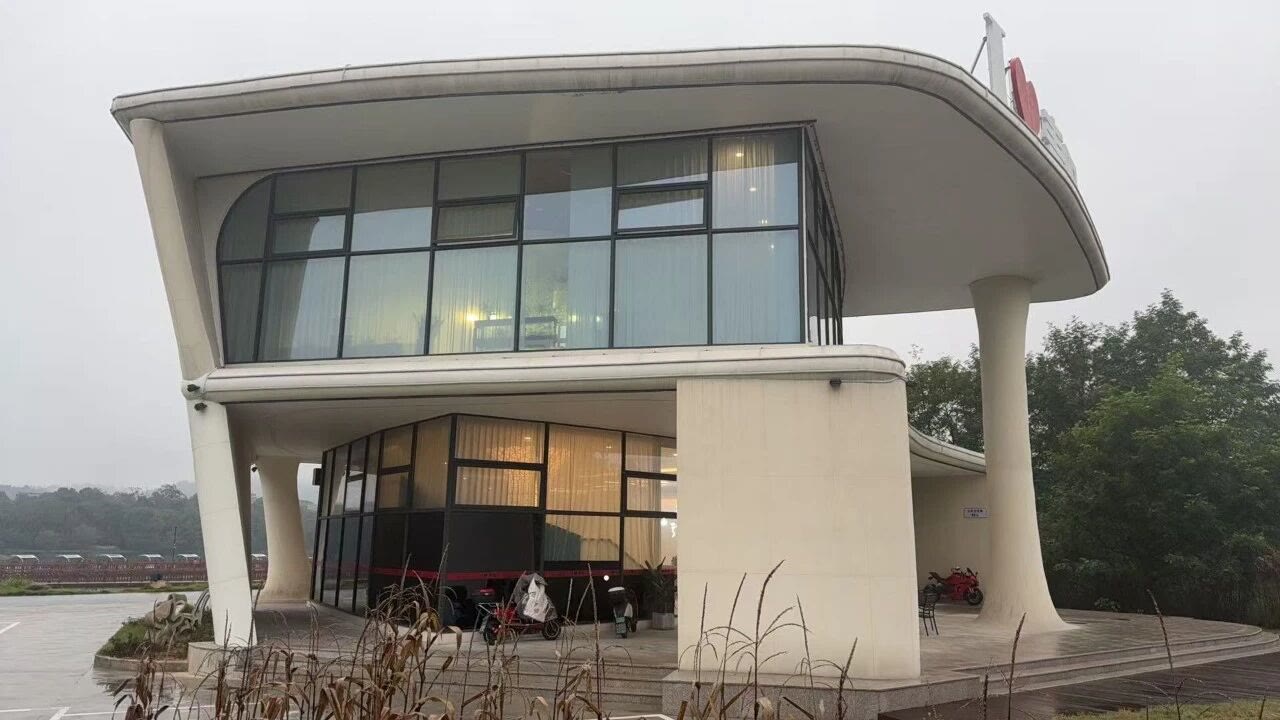 A side view highlighting the extended cantilevered roof and the glass facades.